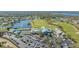 Aerial view of the clubhouse overlooking the golf course and pond, next to a parking lot and tennis courts at 6501 Stone River Rd # 304, Bradenton, FL 34203