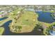 Aerial view of the golf course and surrounding community with a pond, sand trap, and lots of trees at 6501 Stone River Rd # 304, Bradenton, FL 34203