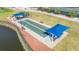 Aerial view of bocce ball court with covered seating areas near the pond, lush landscaping and walking path at 6501 Stone River Rd # 304, Bradenton, FL 34203