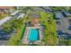 Aerial view of community pool and tennis court surrounded by lush green grass and multiple covered parking spots at 6501 Stone River Rd # 304, Bradenton, FL 34203