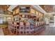 Upscale bar area with hardwood floors, ceiling fans, a full bar, television, and comfortable seating at 6501 Stone River Rd # 304, Bradenton, FL 34203