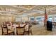Large event space with carpeting, chandeliers, tables, chairs, and a stage area for gatherings at 6501 Stone River Rd # 304, Bradenton, FL 34203