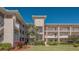 Well-maintained condo building with lush landscaping, manicured lawn, and vibrant plants at 6501 Stone River Rd # 304, Bradenton, FL 34203