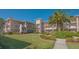 Well-maintained condo building with lush landscaping, manicured lawn, and palm trees at 6501 Stone River Rd # 304, Bradenton, FL 34203