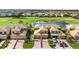 Aerial view of property with golf course and pond in the background, landscaping in the foreground at 6618 Grand Estuary Trl # 101, Bradenton, FL 34212