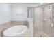 Bright bathroom features large tub, tiled walk-in shower with glass door and tile surround at 6618 Grand Estuary Trl # 101, Bradenton, FL 34212