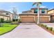 Well-maintained townhome showcasing a brick driveway, tropical landscaping, and a two-car garage at 6618 Grand Estuary Trl # 101, Bradenton, FL 34212