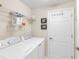 Laundry room features a white washer and dryer with storage shelving at 6618 Grand Estuary Trl # 101, Bradenton, FL 34212