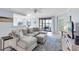Open-concept living room with a view of the kitchen, waterfront patio, and neutral decor at 6618 Grand Estuary Trl # 101, Bradenton, FL 34212