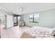 Bedroom with ceiling fan, light plank floors, golf course view, and access to screened lanai at 6618 Grand Estuary Trl # 101, Bradenton, FL 34212