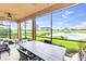 Screened lanai features outdoor dining area with golf course and water view at 6618 Grand Estuary Trl # 101, Bradenton, FL 34212
