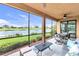 Screened lanai with outdoor seating area and view of the golf course and pond at 6618 Grand Estuary Trl # 101, Bradenton, FL 34212