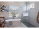 Bright bathroom featuring a free standing tub and a frameless glass shower with gray tile at 7031 Scrub Jay Dr, Sarasota, FL 34241