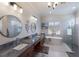 Elegant bathroom with dual sinks, freestanding tub, glass enclosed shower, and bright windows at 7031 Scrub Jay Dr, Sarasota, FL 34241
