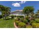 Home exterior with lush landscaping, mature palm trees, and a well-manicured lawn at 7031 Scrub Jay Dr, Sarasota, FL 34241