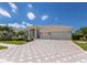 Attractive home with a three-car garage and tile roof, accented by a patterned paver driveway and manicured landscaping at 7031 Scrub Jay Dr, Sarasota, FL 34241