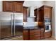 Modern kitchen featuring stainless steel appliances, rich wood cabinetry, and sleek countertops at 7031 Scrub Jay Dr, Sarasota, FL 34241