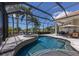 Inviting screened-in pool with jacuzzi, lush landscaping, and outdoor dining at 7031 Scrub Jay Dr, Sarasota, FL 34241