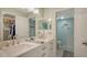 Bright bathroom featuring double sinks, quartz countertops, and a tiled walk-in shower at 7142 Bright Creek Dr # 35, Sarasota, FL 34231