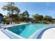 Large community pool with ample lounge seating and lush landscaping on a sunny day at 7142 Bright Creek Dr # 35, Sarasota, FL 34231
