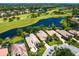 Aerial view of a beautiful home with a tile roof, overlooking a serene lake and lush golf course at 7229 Lake Forest Gln, Lakewood Ranch, FL 34202