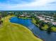 Picturesque aerial view of a home nestled amidst lush greenery, a tranquil lake, and a well-maintained golf course at 7229 Lake Forest Gln, Lakewood Ranch, FL 34202