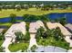 Stunning aerial view of a luxury home with a tile roof, lush landscaping, and waterfront golf course views at 7229 Lake Forest Gln, Lakewood Ranch, FL 34202