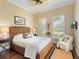 Comfortable bedroom with a ceiling fan, plantation shutters, wood floors and a woven headboard at 7229 Lake Forest Gln, Lakewood Ranch, FL 34202