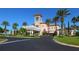Stunning clubhouse exterior featuring a porte cochere, tower, and manicured landscaping at 7229 Lake Forest Gln, Lakewood Ranch, FL 34202