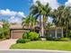 Charming home featuring a well-manicured lawn, lush landscaping, and a neutral color scheme with a tile roof at 7229 Lake Forest Gln, Lakewood Ranch, FL 34202