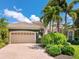 Gorgeous home featuring a paver driveway, lush landscaping, and a grand two-car garage at 7229 Lake Forest Gln, Lakewood Ranch, FL 34202