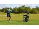 Golfer teeing off on a sunny day with lush green surroundings and a clear blue sky at 7229 Lake Forest Gln, Lakewood Ranch, FL 34202