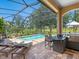 Beautiful pool and outdoor kitchen in screened lanai with view to the golf course at 7229 Lake Forest Gln, Lakewood Ranch, FL 34202