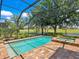 Beautiful screened-in pool and spa with brick patio overlooks lush golf course and waterway views at 7229 Lake Forest Gln, Lakewood Ranch, FL 34202