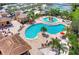 Stunning aerial view of the community pool area, featuring multiple pools, lounge chairs, and lush landscaping at 7705 Grand Estuary Trl # 206, Bradenton, FL 34212