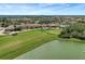 Expansive aerial view of a community with a clubhouse, golf course, and tranquil lake at 7705 Grand Estuary Trl # 206, Bradenton, FL 34212
