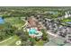 Aerial view showcasing a luxurious community pool, clubhouse, golf course, and tennis court at 7705 Grand Estuary Trl # 206, Bradenton, FL 34212