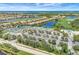 An aerial view shows a community with tennis courts, a pool, a golf course, and multiple lakes at 7705 Grand Estuary Trl # 206, Bradenton, FL 34212