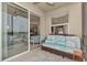 Cozy balcony featuring a comfortable wicker sofa, blue cushions, and view to the indoor living room at 7705 Grand Estuary Trl # 206, Bradenton, FL 34212