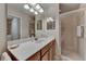 Bright bathroom featuring a single sink vanity, a spacious mirror, and a glass-enclosed shower at 7705 Grand Estuary Trl # 206, Bradenton, FL 34212