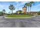 The grand clubhouse entrance is accentuated with swaying palm trees and elegant landscaping at 7705 Grand Estuary Trl # 206, Bradenton, FL 34212