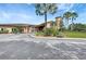 A view of the clubhouse entrance shows golf carts and manicured landscaping at 7705 Grand Estuary Trl # 206, Bradenton, FL 34212