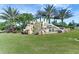 Scenic view of a neighborhood entrance with a rock waterfall and lush landscaping at 7705 Grand Estuary Trl # 206, Bradenton, FL 34212