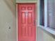 A welcoming red front door with sidelight window for natural light in the entry at 7705 Grand Estuary Trl # 206, Bradenton, FL 34212