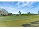 Scenic golf course view with lush green grass, palm trees, and water features under a clear blue sky at 7705 Grand Estuary Trl # 206, Bradenton, FL 34212