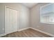 A bedroom with wood-look flooring, a window, and a closet at 7983 Limestone Ln # 14-201, Sarasota, FL 34233