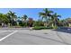 Elegant community entrance with lush landscaping, palm trees, and controlled access, ensuring privacy at 7983 Limestone Ln # 14-201, Sarasota, FL 34233