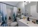 Well-lit bathroom featuring a shower with curtain, a toilet, and a single sink vanity at 8225 Drew St, Englewood, FL 34224