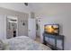 Bright bedroom featuring a beach-themed TV, light walls, and doorways to the bathroom at 8225 Drew St, Englewood, FL 34224