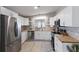 Stylish kitchen with stainless steel appliances, wood countertops, and white cabinetry at 8225 Drew St, Englewood, FL 34224